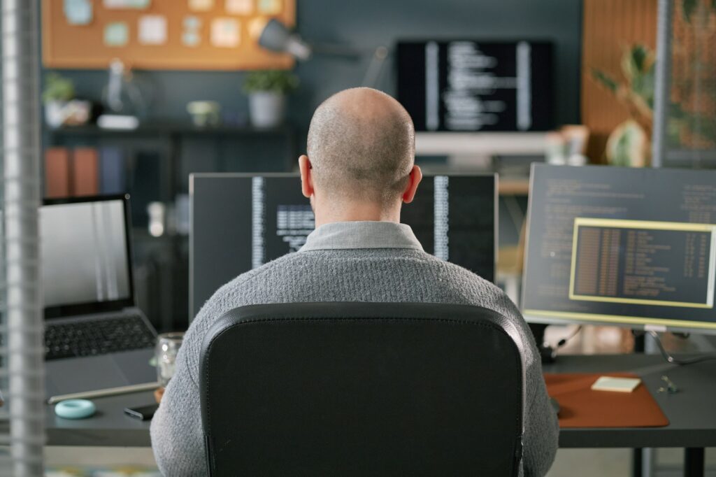 A developer working at a multi-monitor workstation
