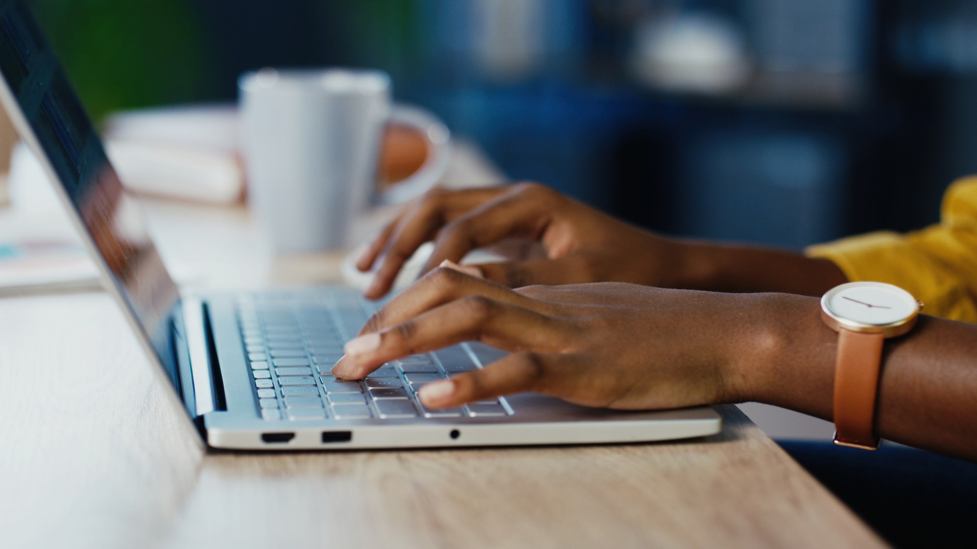 Hands typing on a laptop keyboard